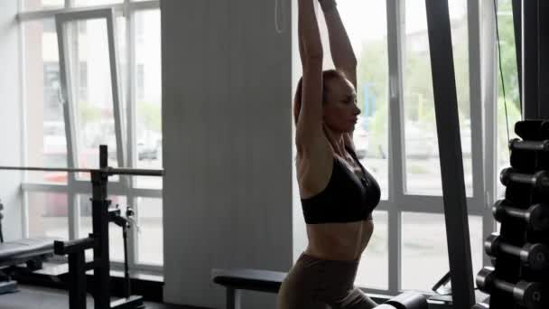Spor Salonundaki Bir Atlet Kız Doğrudan Kol Egzersizi Makinesine Yürür — Stok video