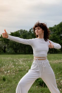 Yoga pozisyonu kavramı açık havada. Genç sporcu kadın profesyonel meditasyon koçu. Yavaşça nefes alıyor ve parmaklarındaki enerjiye konsantre oluyor. Bayan dinlenme egzersizi yapıyor. Yüksek kalite fotoğraf