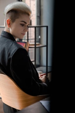 Ofiste çalışan çekici bir kızın dikiz görüntüsü. Kısa saç kesimi olan genç bir kadın röportaj için sırasını bekliyor. Takım elbiseli bir iş kadını. Yüksek kalite fotoğraf