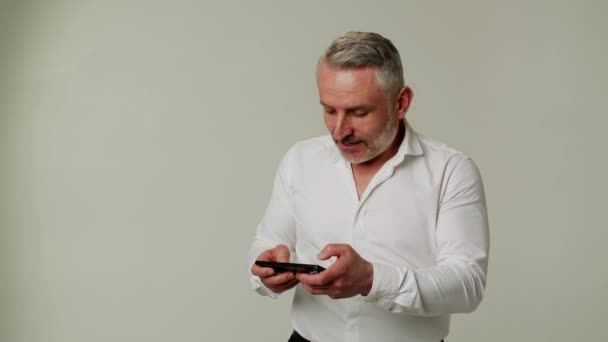 Чоловік Середнього Віку Використовує Смартфон Старанно Грає Ігри Різними Успіхами — стокове відео