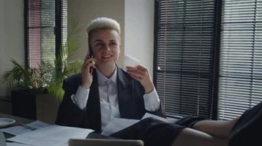 Genç iş kadını ofiste iş günü ara verir. Kahve içen ve telefonla konuşan çekici bayan girişimci. Gayri resmi iş görüşmesi. Bayan yoğun saatlerde iletişim kuruyor. Yüksek kalite 4k