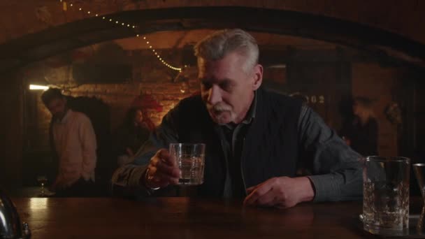 バーでアルコール中毒 大人の男性はバーキーパーと議論し 次のウイスキーを注ぐのをやめた もっとアルコールを求める 高齢者は次のショットを望んでいる 高品質の4K映像 — ストック動画