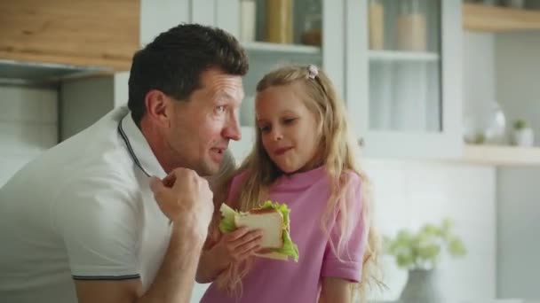 Una Niña Sonriente Alegre Come Sándwich Cocina Junto Padre Padre — Vídeos de Stock