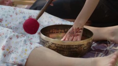 Şaman bir kız refah, uzun yaşam, arzuların tatmin edilmesi, başarısızlıklardan ve hastalıklardan kurtulmak için temizleme ritüeli gerçekleştirir. Tibet pirinç kasesi ve el yapımı değnek hasta kadının ayaklarının yanında
