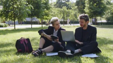 Resmi olmayan açık hava toplantısı kavramı. Doğada iki iş ortağı. Başarılı meslektaşlar proje detaylarını bilgisayar ekranında açıklıyor. Pozitif kadın iş adamıyla konuşuyor. Yüksek kalite 4k