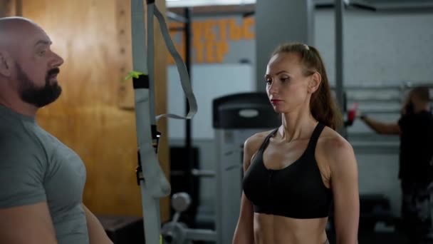 Instrutor Fitness Masculino Ginásio Mostra Uma Atleta Como Usar Arnês — Vídeo de Stock