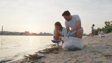 Bir grup çevreci doğadaki çöpleri temizliyor. Doğada plastik bir torba içinde çöp toplayan gençlerin yakın çekimi. Yeşil yaşam ve ekoloji kavramı. Yüksek kalite 4k görüntü