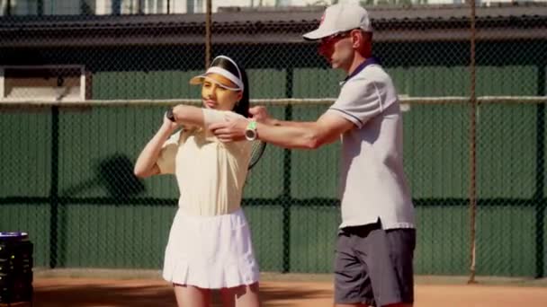 테니스 코치는 그녀의 병동에 가까이 경쟁의 격퇴하기 어깨에 라켓을 제대로 — 비디오