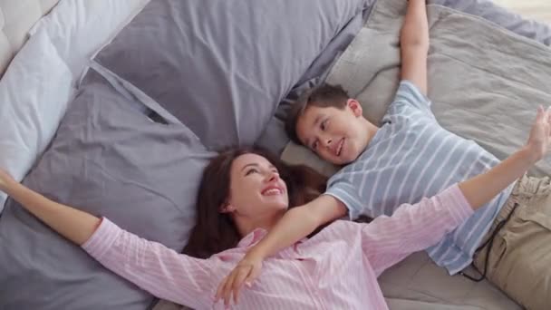 Uśmiechnięta Mama Syn Zabawnym Radosnym Nastroju Leżą Sypialni Łóżku Demonstracja — Wideo stockowe