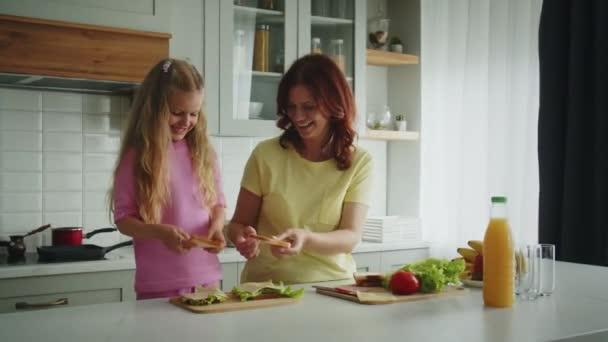 Uśmiechnięta Mama Córka Kuchni Smakują Swoje Gotowe Kanapki Zadowoleni Rezultatu — Wideo stockowe