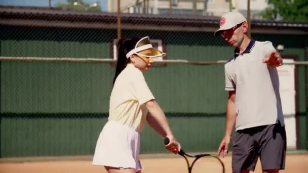 Eine Tennisspielerin Unter Der Schirmherrschaft Eines Männertrainers Zeigt Und Übt — Stockvideo