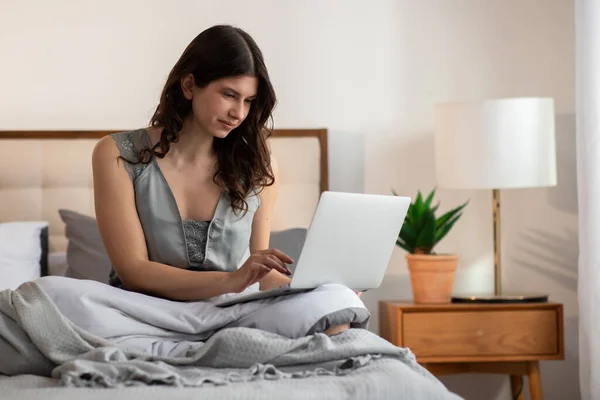 穿着毛毯的微笑的女孩正在床上和笔记本电脑一起工作 从家里工作的想法 高质量的照片 — 图库照片