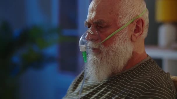 一名老年男子在疗养院或医院里 患有支气管哮喘 呼吸不畅 并使用氧气面罩来缓解呼吸 靠近点高质量的4K镜头 — 图库视频影像