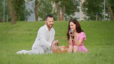 Genç erkek arkadaşın kız arkadaşıyla dışarıda piknik yapıyor. Parkta bir adam ona bir hikaye anlatırken güzel bir kadın şarap içerken gülüyor. Aile çifti kırmızı şarap içip kadeh kaldırıyor.