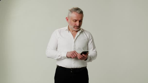 Üzletember Próbál Emlékezni Mobiltelefonszám Elszigetelt Szürke Színű Háttér Magabiztos Középkorú — Stock videók