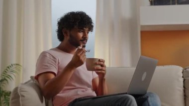 Evde dizüstü bilgisayarla çalışırken hazır şehriye yiyen Hintli serbest çalışan adam. Genç aç adam rahat koltukta oturup bilgisayarda film izliyor. İnternette okuyan bir erkek öğrenci.