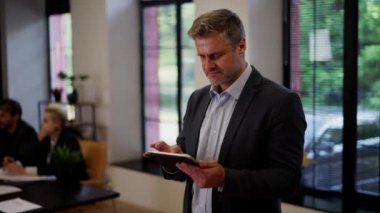 Kendine güvenen veri analizleri yeni ekip üyesi cihazları kontrol ediyor. İş adamı bilgi araştırması için tablet kullanıyor. Başarılı girişimci takım oluşturma geçmişindeki e-postaları kontrol eder. Yüksek kalite 4k