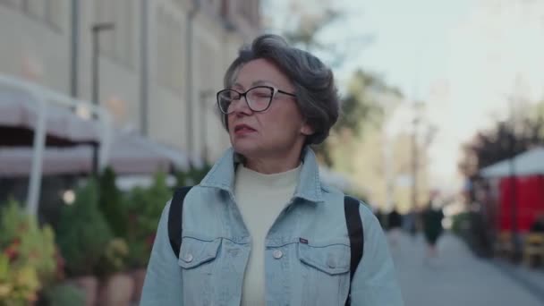Starsza Kobieta Spaceruje Ulicach Miasta Słoneczny Wiosenny Dzień Dama Jest — Wideo stockowe