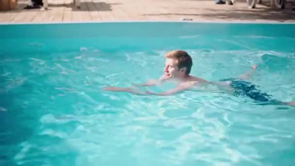 人们喜欢在游泳池里度过暑假 年轻人在当地的度假胜地潜水 在户外蓝色的水里游泳 放松男性享受泳池派对 成年商人新鲜 高质量的 — 图库视频影像