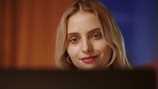 一个年轻漂亮的金发姑娘 带着自信和满意的目光看着电脑显示器或笔记本电脑的屏幕 一位面带微笑的商界女士读到有关工作的好消息 觉得自己是个情妇 — 图库视频影像
