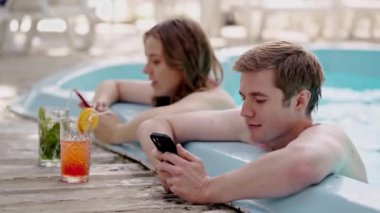 Yüzme havuzunda dinlenirken iş arkadaşlarına akıllı telefonlardan mesaj atmakla meşguller. Genç erkek arkadaş ve kız arkadaş tatildeyken cep telefonu kullanıyor. İnsanlar her gün uzaktan kumandayla iş yapıyor.