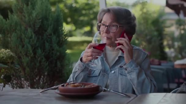 Allvarlig Pensionär Kvinna Dricker Rött Vin Terrassen Restaurang Och Har — Stockvideo