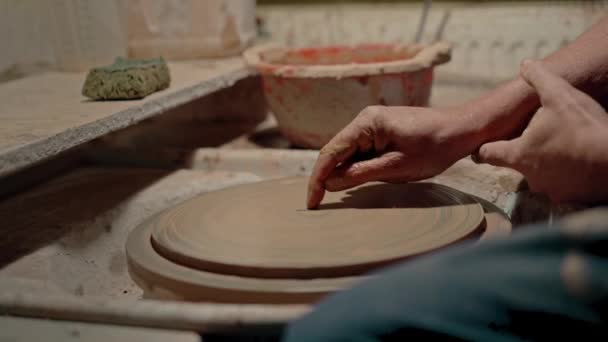 アーティストは陶器の回転に粘土の花を描いています 職人のワークショップの雰囲気 汚れた職場でのプレートの装飾のマスタークラス ドローイングスキル 高品質の4K映像 — ストック動画