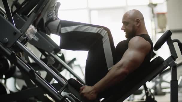 Man Bodybuilder Zijwaarts Sportschool Training Machine Geconcentreerd Oefening Voor Beenkracht — Stockvideo