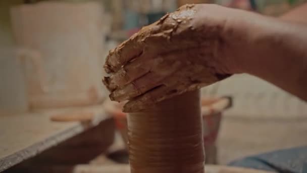 专业的陶工手在扭曲的纺轮上做陶瓷壶 肮脏的手臂在车间里雕刻一个粘土花瓶 雕塑家雕塑家 小家族企业 高质量4K — 图库视频影像