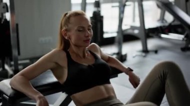 Spor aletleri konusunda yalan söyleyen bir kız sporcu bacaklarını ve sırtını eğitiyor. Bir sporcu kadın tek bacağı bükük bir şekilde vücudunu kaldırır. Esnekliğin ve mükemmel sporun gösterimi