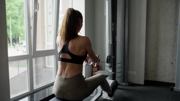 Uma Atleta Academia Perto Janela Faz Exercícios Sentada Uma Máquina — Vídeo de Stock