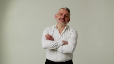 Olgun şirketin CEO 'su gri arka planda izole edilmiş kollarını katlamış. Beyaz gömlekli başarılı bir iş adamı. Kendine güvenen girişimci poz veriyor ve yeni zorluklara hazır. Yüksek kalite 4k görüntü