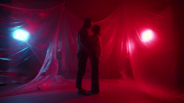 一对年轻夫妇正在演播室接吻 两个情人在屋里接吻 美丽的家庭拥抱 在霓虹灯下调情 性感对浪漫前戏 高质量的4K镜头 — 图库视频影像
