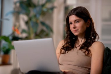 Evde dizüstü bilgisayar kullanan serbest çalışan bir kızın seçici odağı. Bilgisayar klavyesinde yazan genç bir kadın. Ev kavramından çalış. Yüksek kalite fotoğraf