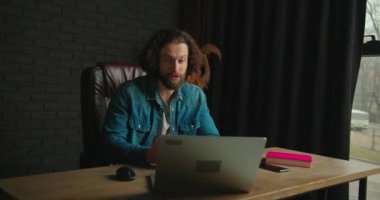 Genç enerjik bir adam ZOM 'da öğrencilerle çevrimiçi bir toplantı yapıyor. Mali konulardan bahsediyor, toplantı sırasında kahve içiyor. Genç adam ilginç yeni bilgiler veriyor. Yüksek kalite 4k görüntü