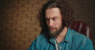 Dizüstü bilgisayarla çalışan bir adamın yakın çekimi. Sakin bir adam internette metni düzenler ve yeni bir görev düşünür. Geniş, geniş bir ofiste online çalışıyorum. Yüksek kalite 4k görüntü