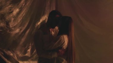 Stüdyodaki sarılan çiftin arka plandaki ışıkları kapatma hareketi. Genç erkek arkadaş, kız arkadaşıyla evde sarmaş dolaş. Yıldönümü çekimleri için beyaz kıyafetler giyen romantik bir çift. Yüksek