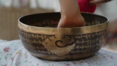 Şaman bir kız refah, uzun yaşam ve arzularını tatmin etmek için arınma ritüeli gerçekleştirir. Doğulu şifacı Tibet pirinçten kasesi ve el yapımı değnek kullanır. Kadın sabırlı, müzik dinliyor.