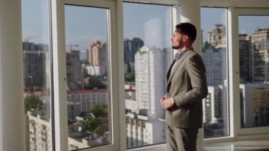 Man sitting on the roof of a big building and look at the city. Concept of big money, success, when dreams comes true. High quality 4k footage