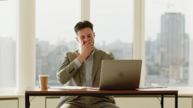 Ofiste çalışan yakışıklı bir iş adamı. Dizüstü bilgisayarda yazan odaklanmış genç bir adam. Dolly vurdu. Gün ışığı. Teknoloji. - Evet. Yüksek kalite 4k görüntü