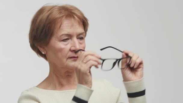 Äldre Leende Kvinna Håller Glasögon För Att Korrigera Dålig Syn — Stockvideo