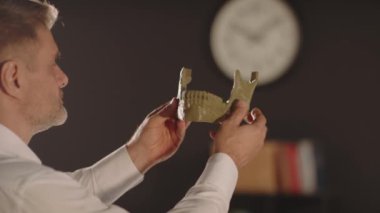 Grafik tasarımcı bir adam dizüstü bilgisayar kullanır, kırmızı ve sarı renkli vazo çizimi yapar ve geometrik formda bir vazo yapar. Bir 3D yazıcı otomatikleştirilmiş otonom işlemde çalışır. Konsept: