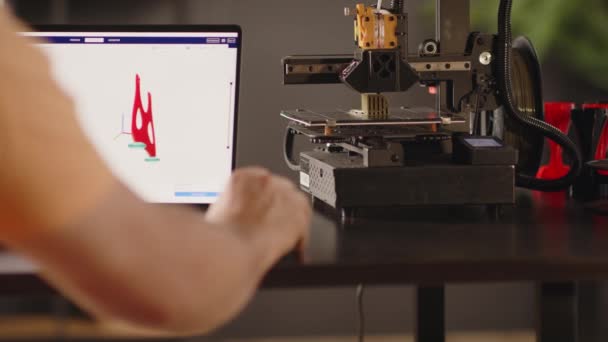 男性のグラフィックデザイナーは ラップトップ画面に描かれた女性の心臓と胸のための赤い色の術後の固定包帯のモデルを開発します 3Dプリンター機械は自動で動作します — ストック動画