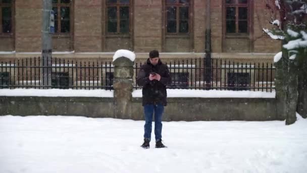 Один Молодой Парень Зимой Ждет Свою Девушку Снежную Бурю Студент — стоковое видео