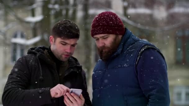 Twee Volwassen Mannen Die Buiten Een Gesprek Voeren Terwijl Sneeuwen — Stockvideo