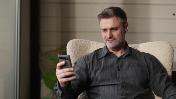 Father Sitting Home Armchair Using Smartphone Reading His Daughter Reached — Stock Video