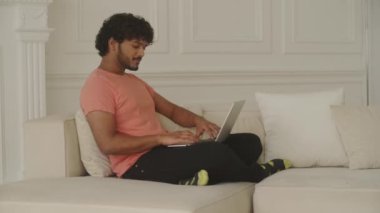 Afro-Amerikalı bir erkek öğrenci oturma odasındaki kanepede yan oturup uzaktan ders çalışıyor. Genç bir girişimci iş yazışmaları için dizüstü bilgisayar kullanır. Birleşim konsepti