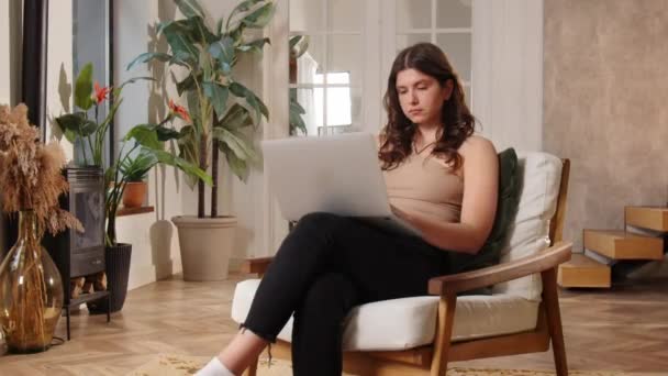 Una Joven Morena Está Sentada Una Silla Con Portátil Regazo — Vídeos de Stock