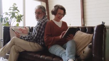 Alet kampanyasının atış süreci. Emekli çift gülümseyerek akıllı telefon ve dijital tablet kullanıyor. Yüksek kalite 4k görüntü