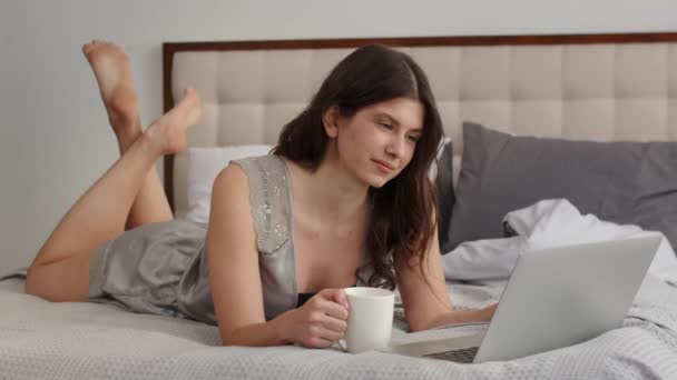 Привлекательная Молодая Женщина Лежит Кровати Чашкой Кофе Смотрит Ноутбуке Красивая — стоковое видео